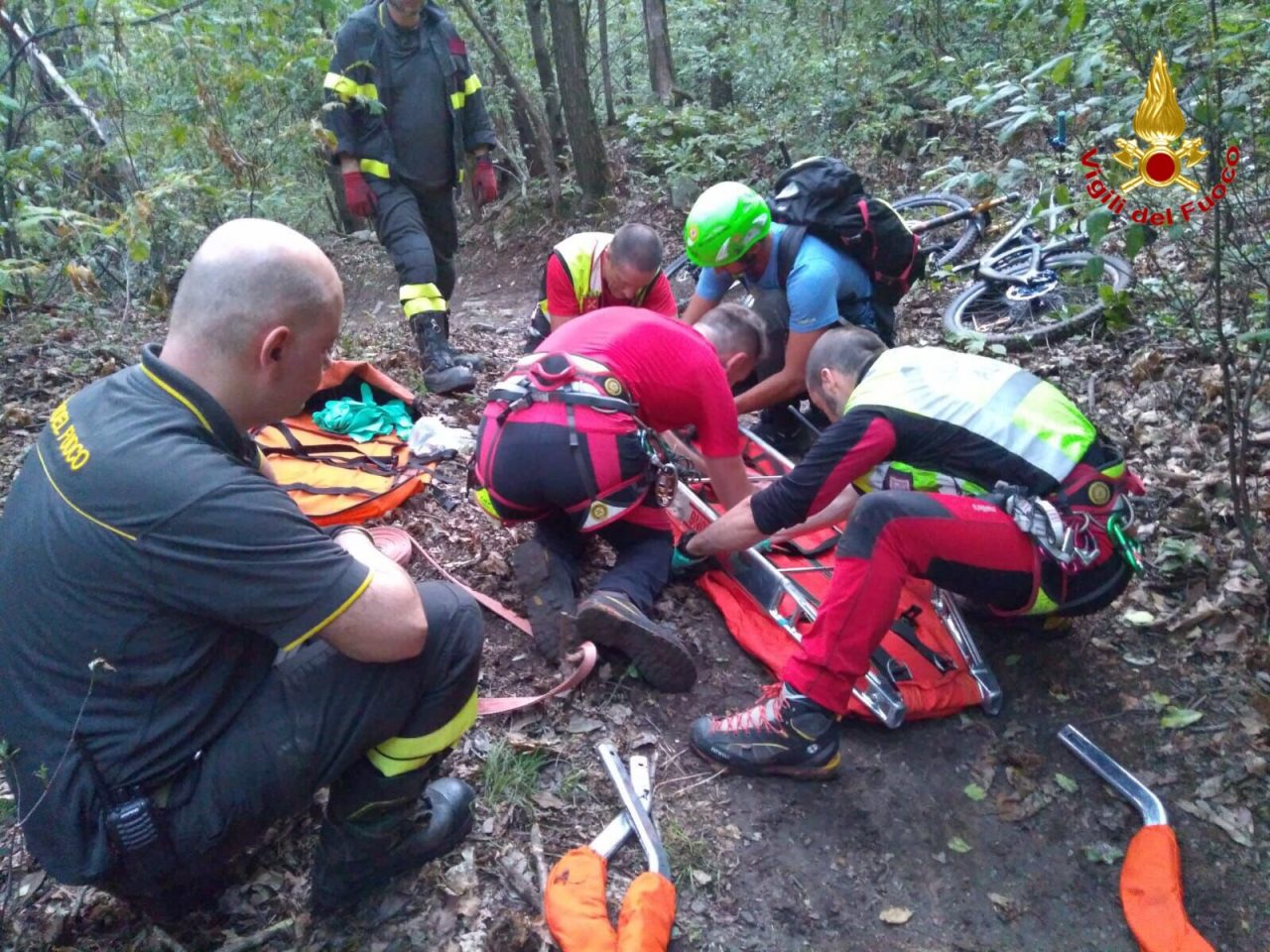 Ciclista soccorso lungo un sentiero di montagna