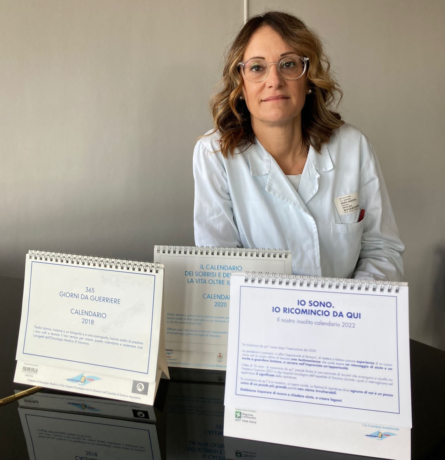 la dottoressa Maria Marconi, con il nuovo e i vecchi calendari realizzati insieme ai suoi pazienti