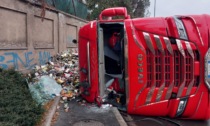 Camion carico di rifiuti si ribalta alla rotonda