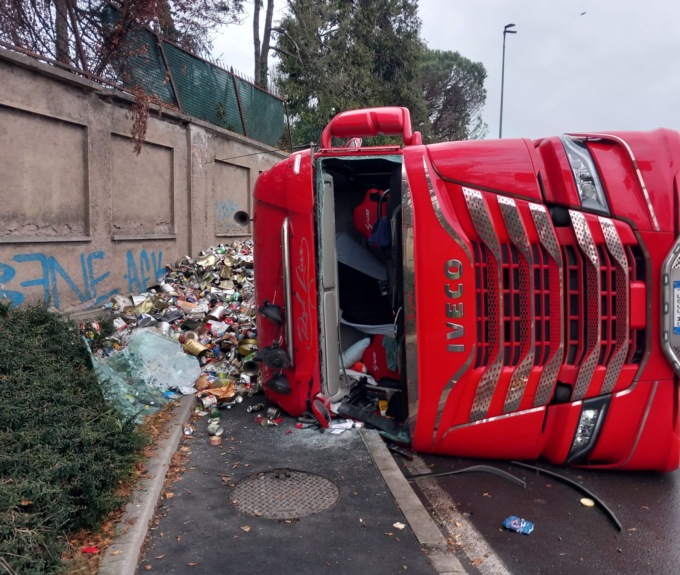 Camion carico di rifiuti si ribalta alla rotonda