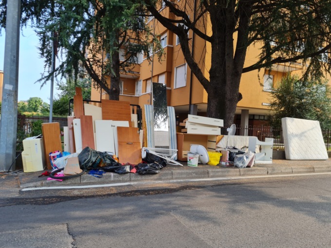 Mobili e rifiuti abbandonati in strada di fianco alle case